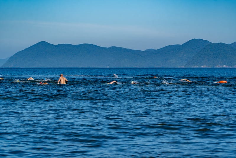 Mar calmo e transparente da Praia do Indaiá em Bertioga com o Morro da Pedra Selada ao fundo