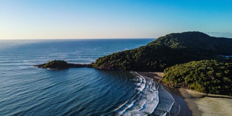 Praia do Indaiá em Bertioga - mar calmo, cristalino e areia clara com vegetação nativa ao fundo